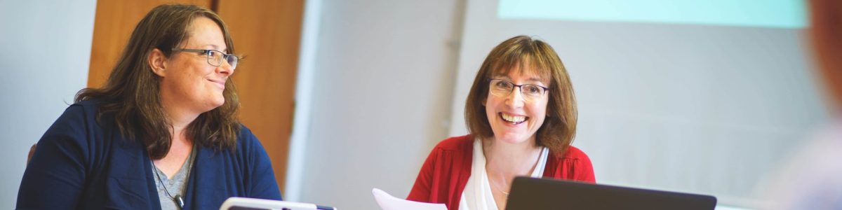 Kate smiling in a business meeting.